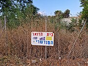 שלט על גדר בית הדואר המספר את סיפור המבנה עם תמונות, אוגוסט 2024