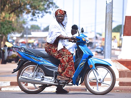 Old woman sitting on a motorcycle in Benin