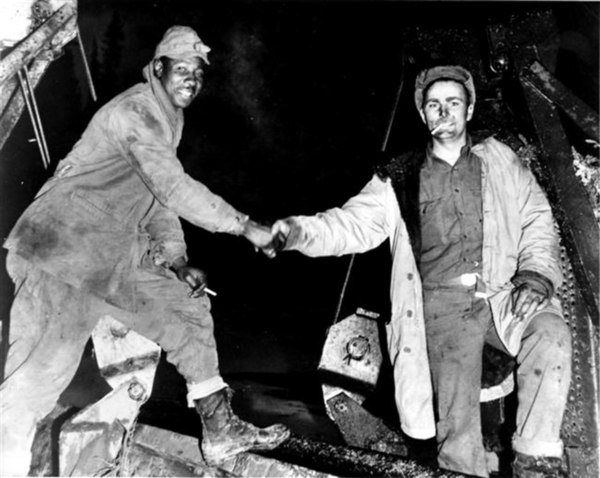 Soldiers of the U.S. Army Corps of Engineers meeting in the middle after completing construction of the Alaska Highway