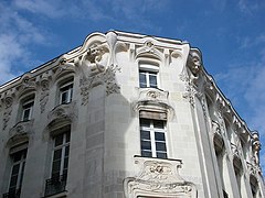 Fotografie din partea de sus a unei fațade a clădirii decorată cu busturi de femei.