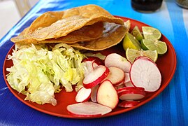 A plate of condiments for pozole