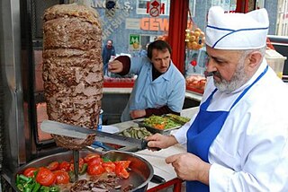 A cook slices ingredients into a skillet