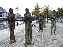 6 statues de bronze, plus grandes que nature, quatre hommes dont un porte un enfant, deux femmes, décharnés, hébétés, en haillons