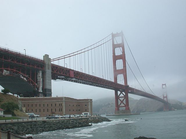 Un bâtiment devant un pont rouge.