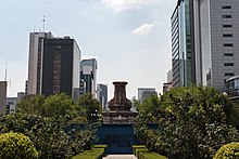 Un pedestal vacío rodeado por una valla protectora.