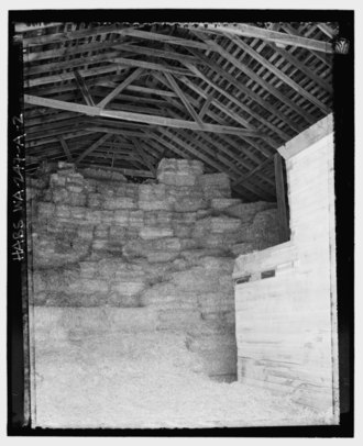 Interior of a barn with a Fink truss, with the characteristic W shape. INTERIOR OF THE BARN ADDITION WITH FINK TRUSS SYSTEM, LOOKING EAST. (Straw bales stored in the barn addition, with the north faand-231;ade of the slaughter house on the right.); - HABS WA-247-A-2.tif