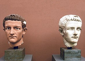Marble bust of Caligula with traces of original paint beside a plaster replica trying to recreate the polychrome traditions of ancient sculpture.