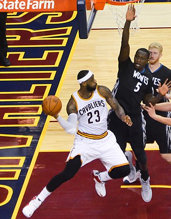 James throws a pass as Gorgui Dieng defends in December 2014. Later that season, James reached several passing milestones, including becoming the Cavaliers' all-time assists leader.[175][176]