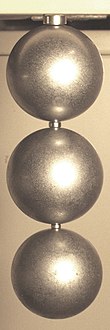 Neodymium magnets (small cylinders) lifting steel balls. As shown here, rare-earth magnets can easily lift thousands of times their own weight. Neodymium magnet lifting spheres.jpg