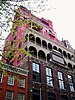 Partial view of the Palazzo Chupi, a bright pink palazzo style structure, built on top of an older four story building