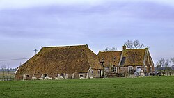 Onbewoonde boerderij op Ranum 7 met steunberen tegen de muur.