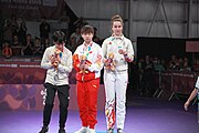 Deutsch: Tischtennis bei den Olympischen Jugend-Sommerspielen 2018: Tag 4, 10. Oktober 2018, Mädchen-Einzel, Siegerehrung - Gold: Yingsha Sun (CHN), Silber: Miu Hirano (JPN), Bronze:Andreea Dragoman (ROU)); Medaillen überreicht durch IOC-Mitglied Ching-kuo Wu (TPE), Maskottchen überreicht durch ITTF-Vize-Präsident Masahiro Maehara (JPN) English: Fencing at the 2018 Summer Youth Olympics at 10 October 2018 – Girls' single medail ceremony – Gold: Yingsha Sun (CHN), Silber: Miu Hirano (JPN), Bronze:Andreea Dragoman (ROU)); Medal presenter: IOC member Ching-kuo Wu (TPE), Mascot presenter: Vice-President Executive of the ITTF Masahiro Maehara (JPN)