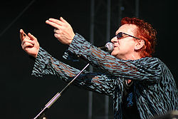 The departure of Wayne Hussey (pictured in 2004) from the band and his "cliched lyrics" served as the inspiration for the lyrics of "This Corrosion". The mission wayne hussey.jpg