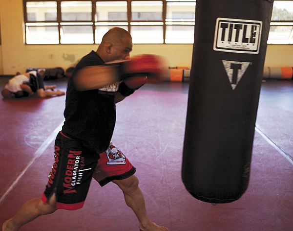 A mixed martial arts fighter "working his hands" on a heavy bag