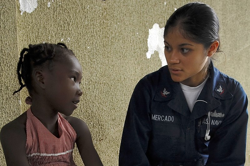 File:US Navy 081015-N-1508S-065 Information Systems Technician 3rd Class Merced Mercado from the amphibious assault ship USS Kearsarge (LHD 3) translates a Dominican patient's symptoms to medical personnel at the Bayaguana Sports Co.jpg