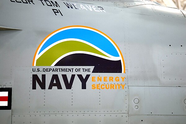 A U.S. Navy F/A-18 Super Hornet displaying an "Energy Security" logo.