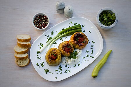 Stuffed peppers served with spring onion, sour cream, bell pepper, leblebi, parsley and slices of bread