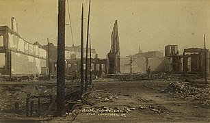Looking north on First Avenue South immediately after the fire in June 1889. The ruins of the Yesler-Leary Building would soon be demolished to allow the street to continue straight through, with the triangular park to its right (east). Photograph by Boyd & Braas. Annotated.