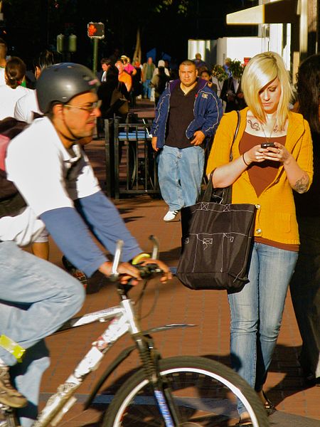 File:Blonde woman with tattoos texting on street.jpg