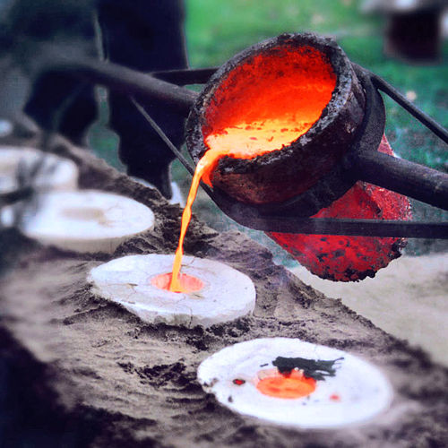 Liquid bronze, being poured into molds during casting