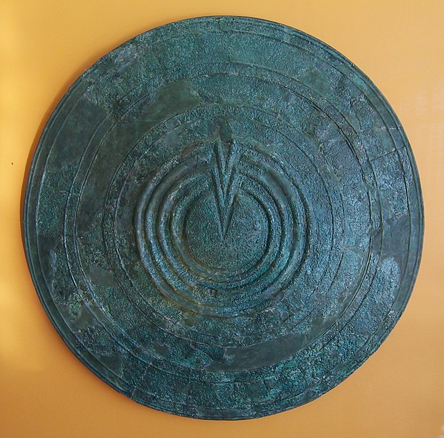 An Ancient Greek warrior's shield—its circular shape and gently sloping surface, with a central raised area, is a shape shared by many shield volcanoe