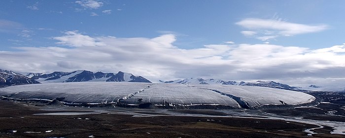 "The Mothership", a 3-mile-wide (4.8 km) terminal lobe of a glacier flowing down from the interior ice cap on top of the Byam Martin Mountains, Bylot Island, Nunavut, Canada. Note the terminal moraine "bulldozed" at the ice front. Bylot Island Glacier (cropped).jpg