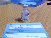 A vaccine card issued in the United Kingdom COVID-19 AstraZeneca Vaccine vial and NHS record card.jpg