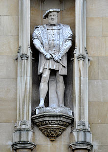 Statue blanche d'un homme portant une ample tunique située dans une niche dans un mur
