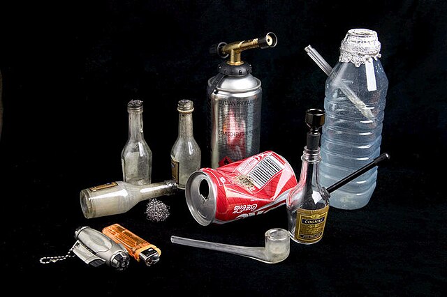 Various paraphernalia used to smoke crack cocaine, including a homemade crack pipe made out of an empty plastic water bottle.