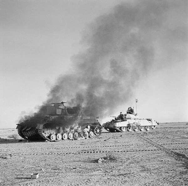 British Crusader tank passes a destroyed and smoking German Panzer IV tank during Operation Crusader, November 1941