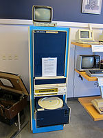 Ordinateur colonne avec un écran au-dessus et un tiroir ouvert contenant un large disque dur.