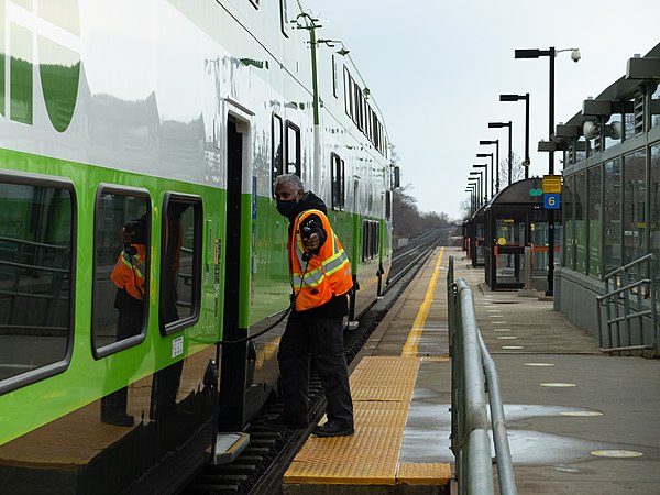 A CSA points at the doors at Rouge Hill Station after closing them for safety. This "shisa kanko" method was adopted by GO Transit in March 2021.
