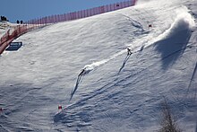 Pemain ski dan membimbing pemain ski ski menuruni gunung