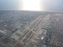 Modern aerial view of Los Angeles International Airport—runway 07R is located to the left and Santa Monica Bay in the background.