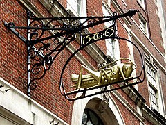 Gresham's initials "TG" and date 1563 with his golden grasshopper emblem, serving as the sign of a bank[9] in Lombard Street, the historic centre of banking in the City of London