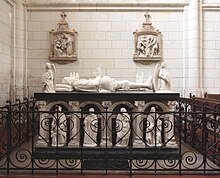 Photographie en couleurs d'un tombeau entouré de grilles et décoré de gisants.