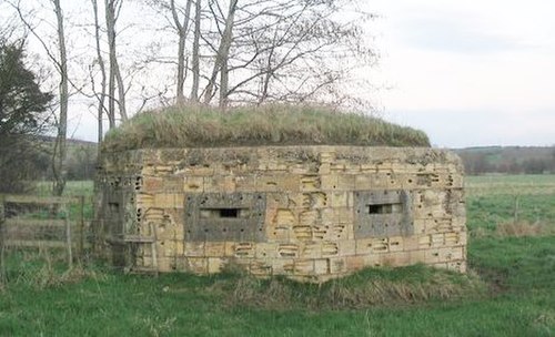 A World War II hexagonal pillbox on the bank of the Mells River at Lullington, Somerset, England