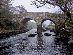 A modern view of the bridge, showing recent repairs. The high-water mark can be seen on the central column. Old-Weir-Bridge-Killarney-National-Park-2012.JPG