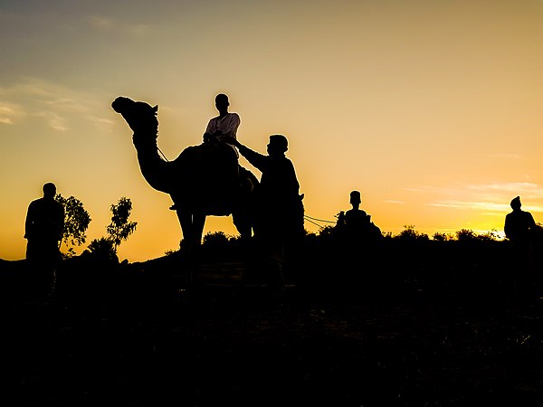 On a camel by sunset in Tiga at former Rock Castle Hotel by Solasly