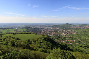 Blick vom Albtrauf nach Norden über Pfullingen auf die Achalm (knapp unterhalb des rechten Horizonts), vom südwestlich gelegenen Schönbergturm aus gesehen. In der linken Bildhälfte der etwas niedrigere Georgenberg (Fotografie Mai 2013)