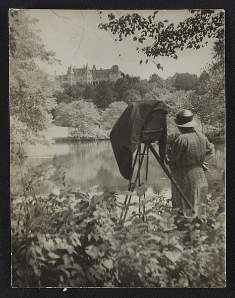 File:Photographer Frances Benjamin Johnston standing beside her view camera looking towards the Biltmore Estate mansion in the background LCCN2012645986.jpg