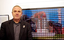 Photographer Thomas Kellner in front of his picture of the steel-company JSC Pervouralsk Novotrubny Plant.jpg