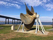 One of the ship's propellers by the Throgs Neck Bridge in New York Prop with bridge.jpg