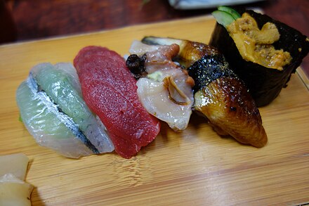 Several types of nigirizushi, rice hand-pressed with various seafood, including tuna, eel, and sea urchin roe gunkanmaki