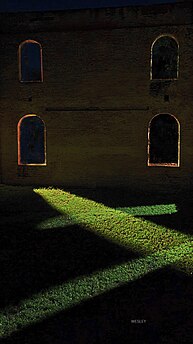 Light pours in from the Synagogepad through the arched windows of the Honen Dalim Synagogue at night. Photographer: StatiaWesley