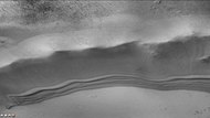 Enlargement of dunes along northern wall (near top of image) of Trumpler Crater, as seen by CTX camera (on Mars Reconnaissance Orbiter). In this image the dunes are not defrosting, as in another image. Dark lines at the top are dust devil tracks on the floor of keeler Crater. Note: this is an enlargement of the next image of Keeler Crater.