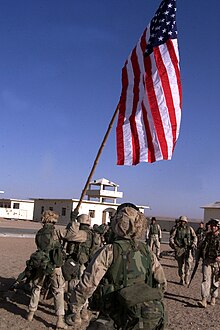 Marines from Battalion Landing Team 1/1 of the 15th Marine Expeditionary Unit raise the first U.S. flag at Camp Rhino during Operation Enduring Freedom, 25 November 2001 011125-M-4912C-006 Raise the Flag.jpg