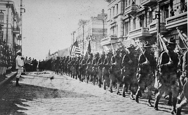 American troops in Vladivostok parading before the building occupied by the staff of the Czecho-Slovaks.