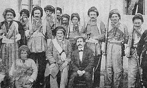A group of men, most with weapons
