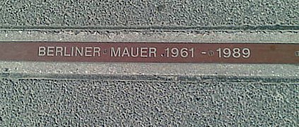 Табличка «BERLINER MAUER 1961–1989» возле контрольно-пропускного пункта Чарли, обозначающая, где стояла Стена.